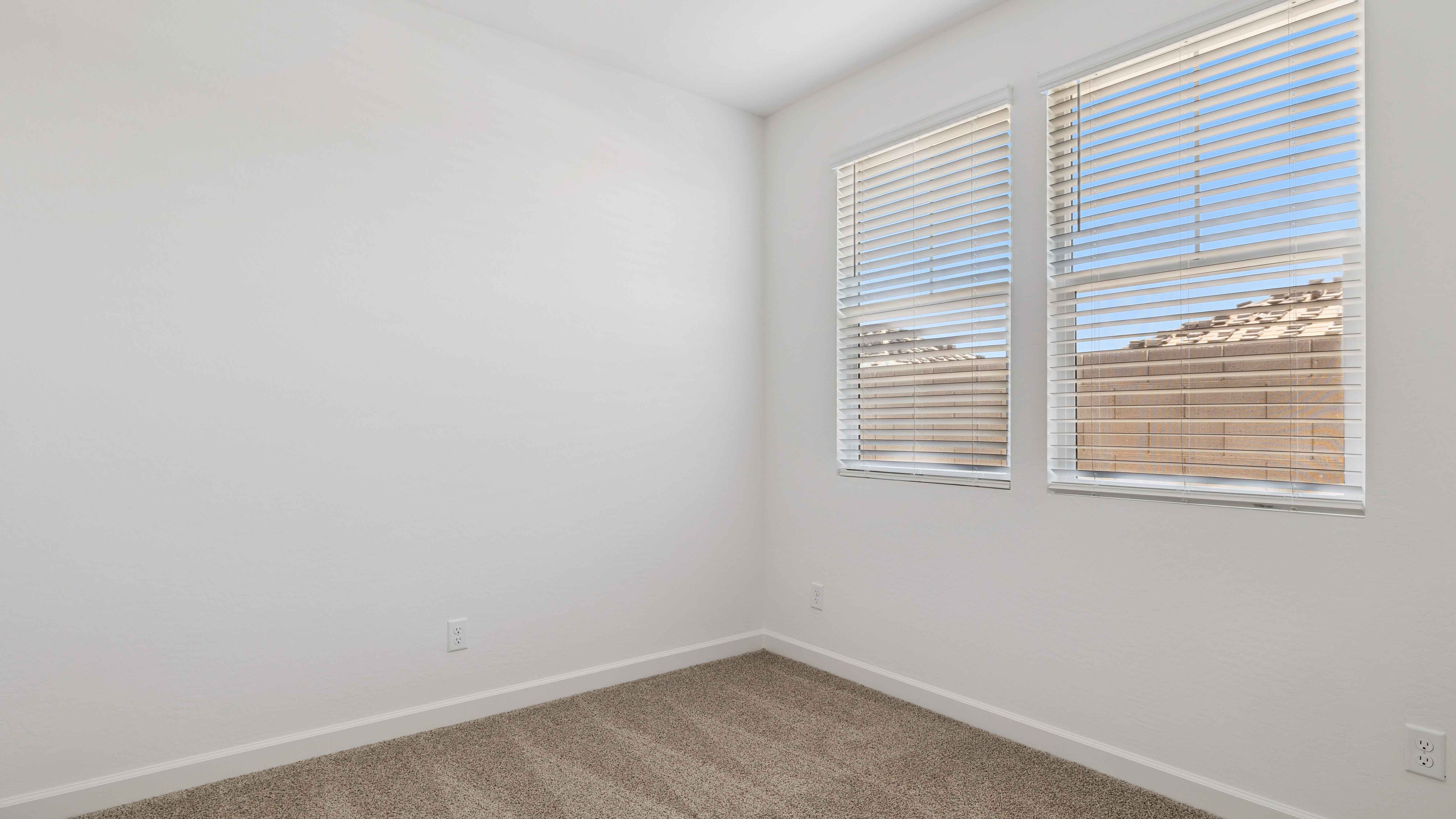 Comfortable guest bedroom featuring neutral-toned walls and a large closet.