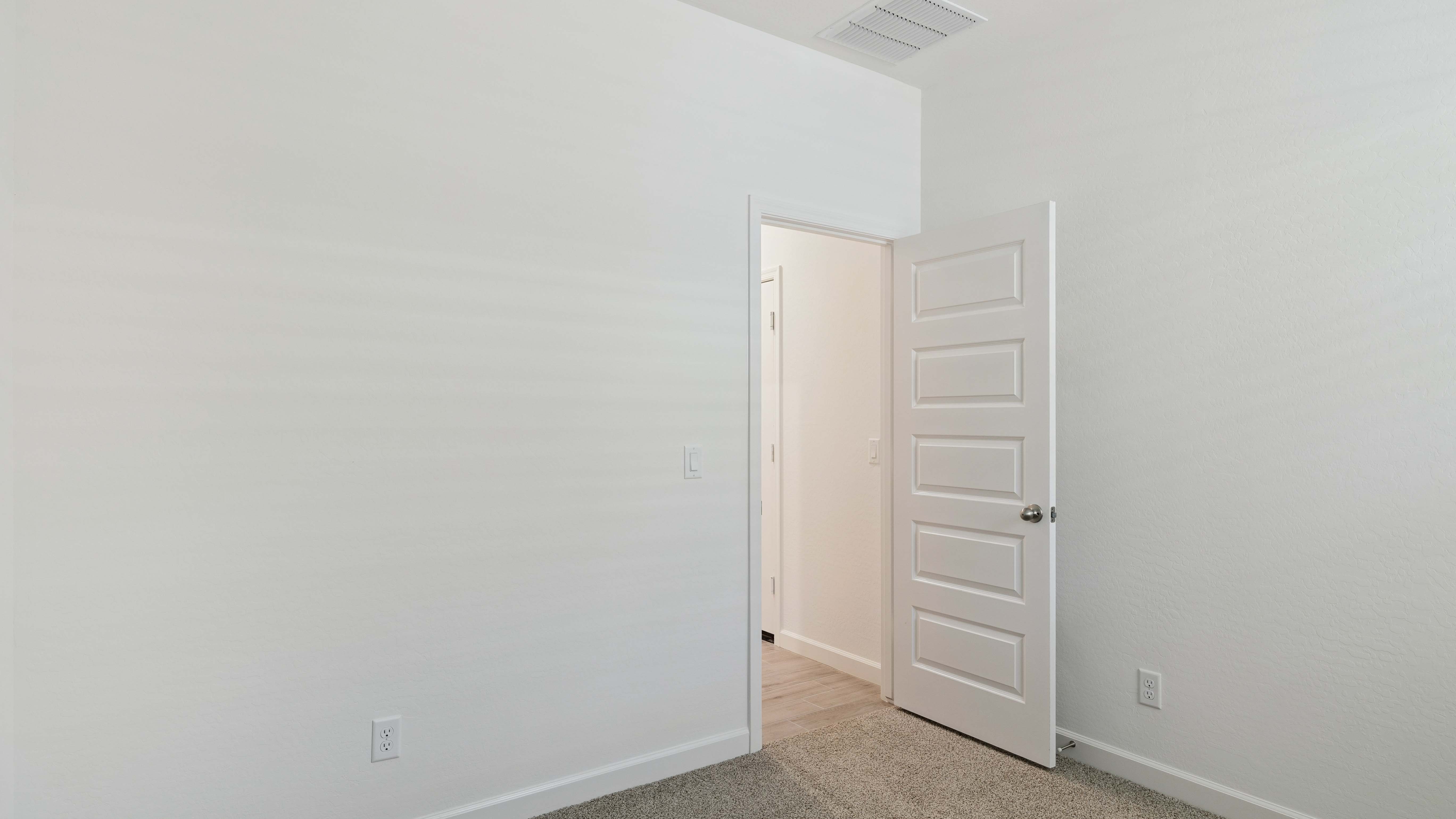 Comfortable guest bedroom featuring neutral-toned walls and a large closet.