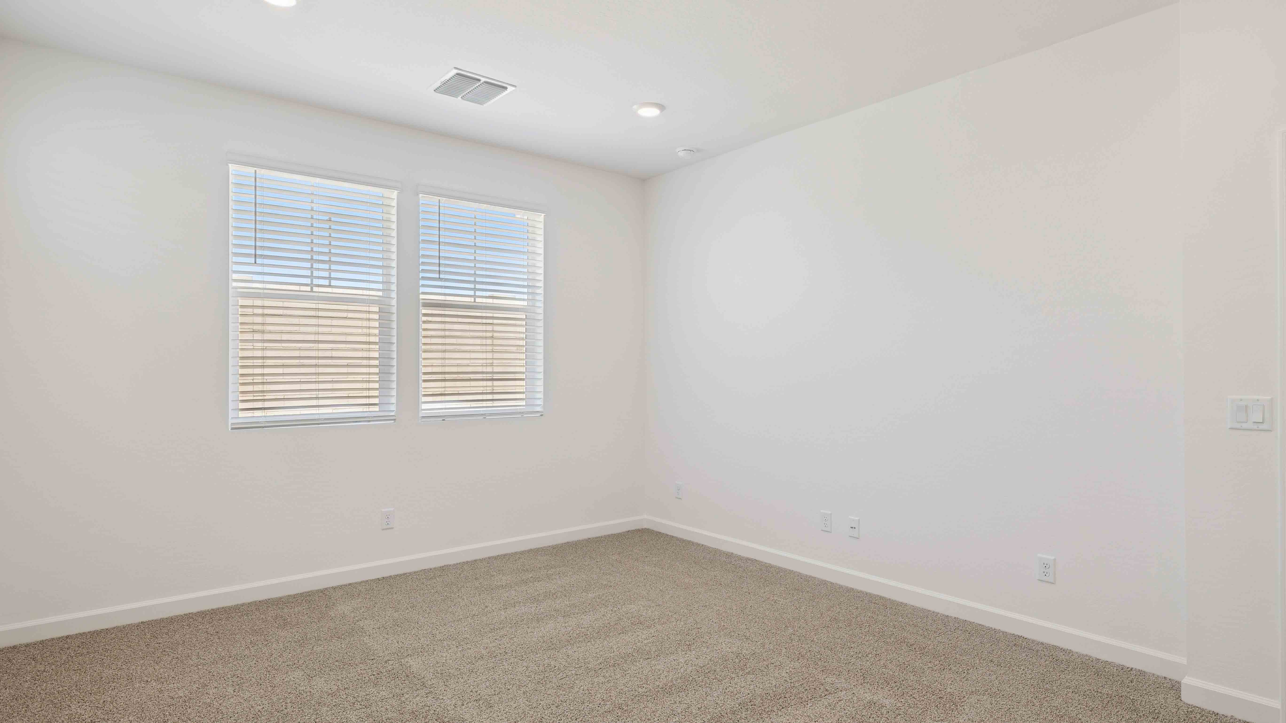 A spacious primary bedroom emphasizing open space and natural lighting.