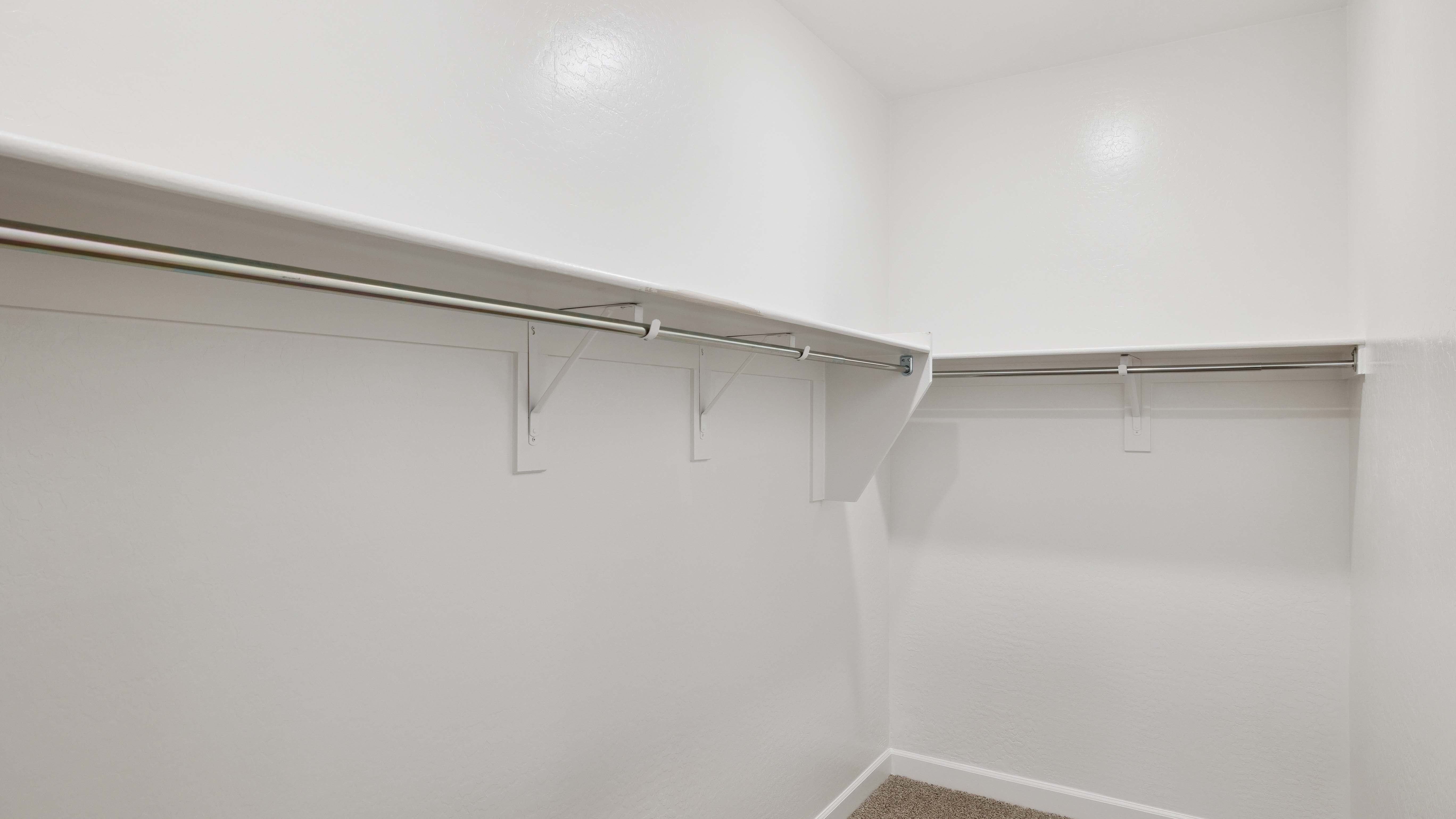 Modern primary bathroom with double vanities, quartz countertops with a walk-in shower and a walk-in closet.