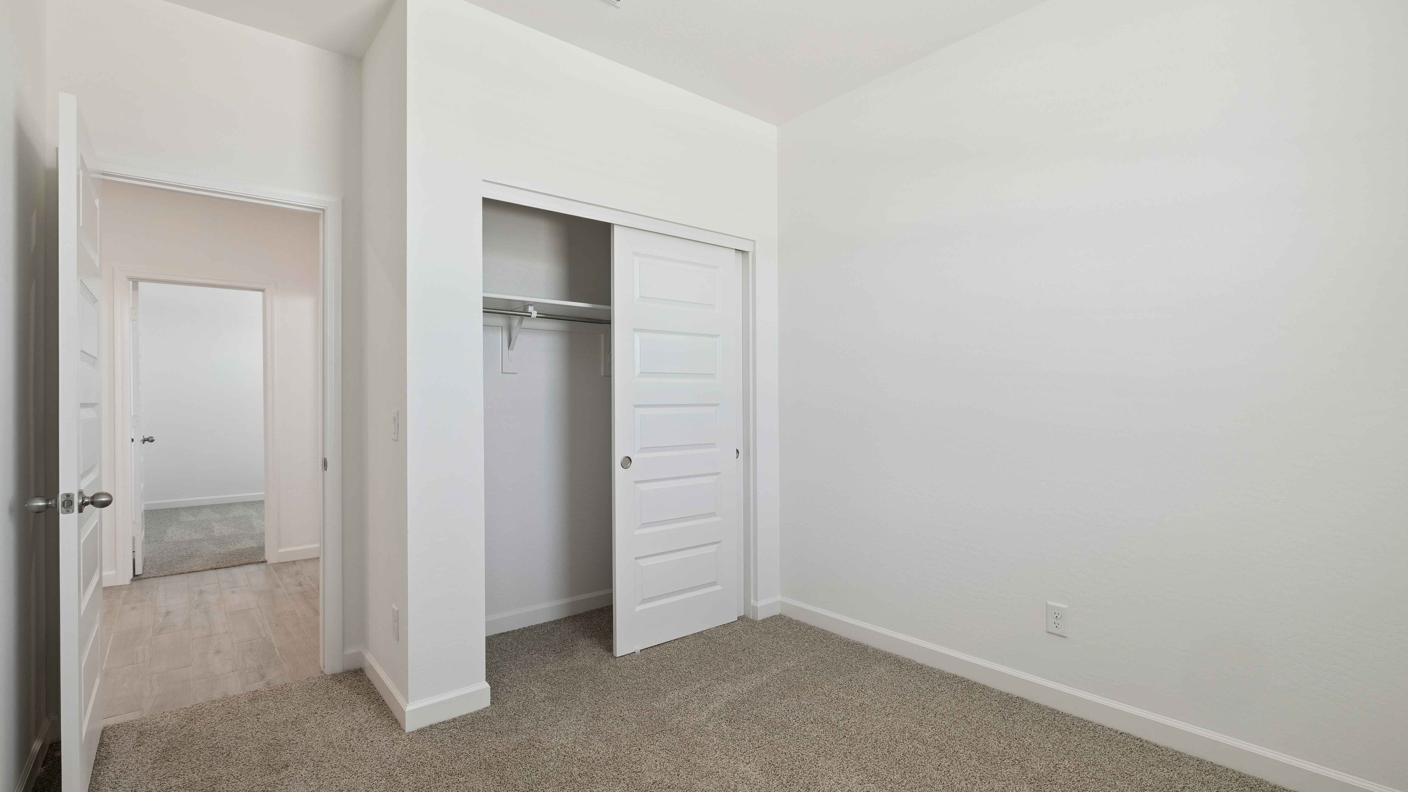 Comfortable guest bedroom featuring neutral-toned walls and a large closet.