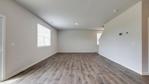 Living room in new, open-concept home with windows and natural lighting