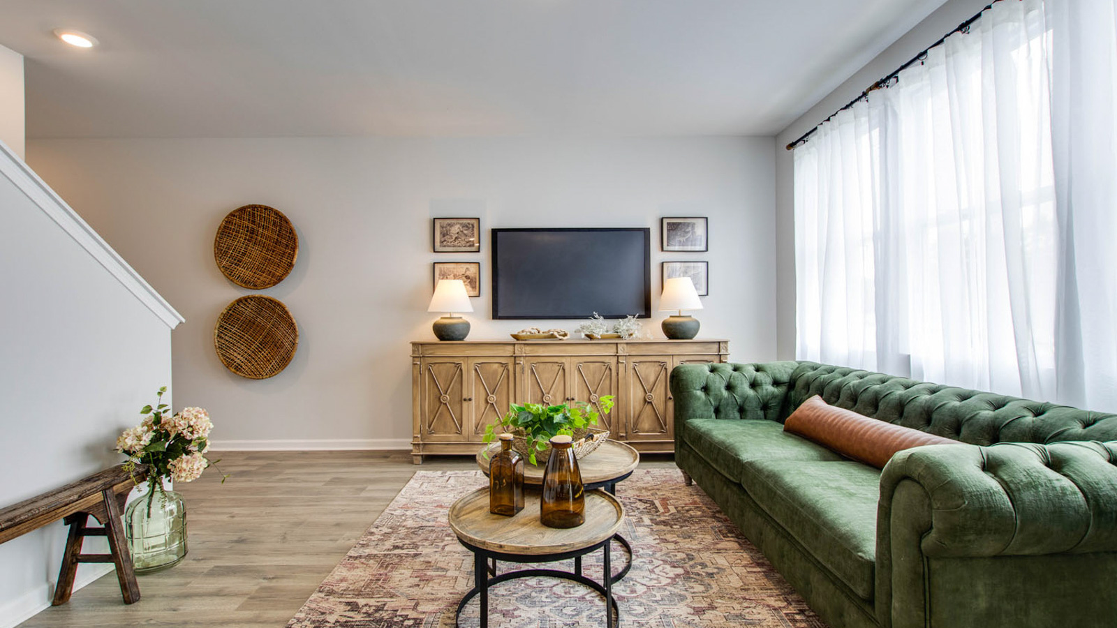 Living room looking to dining and kitchen areas in this new home features natural light, with fresh open concept flow