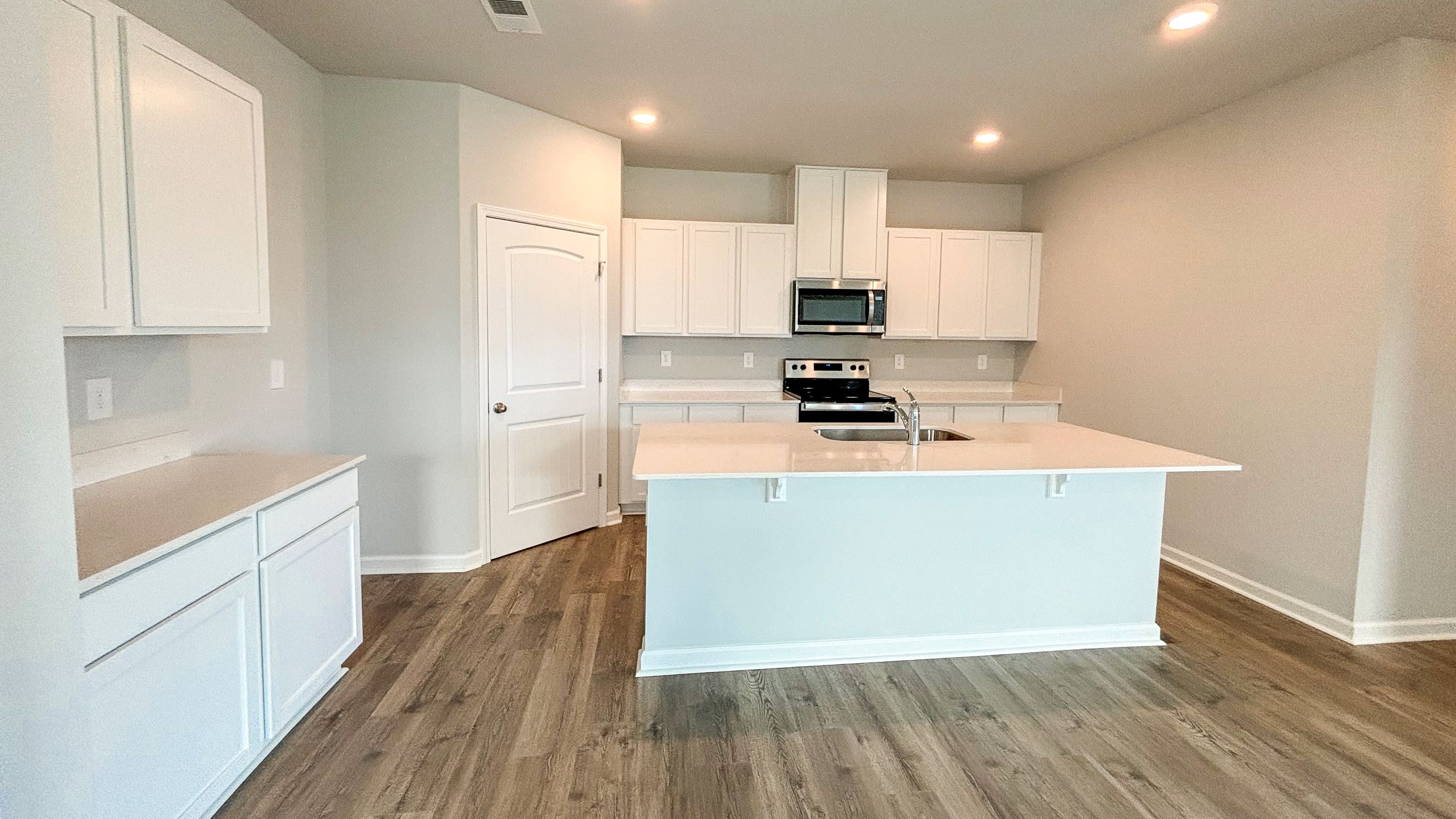 View from living room into dining room, connected to the kitchen, outdoor backyard access at River Landing