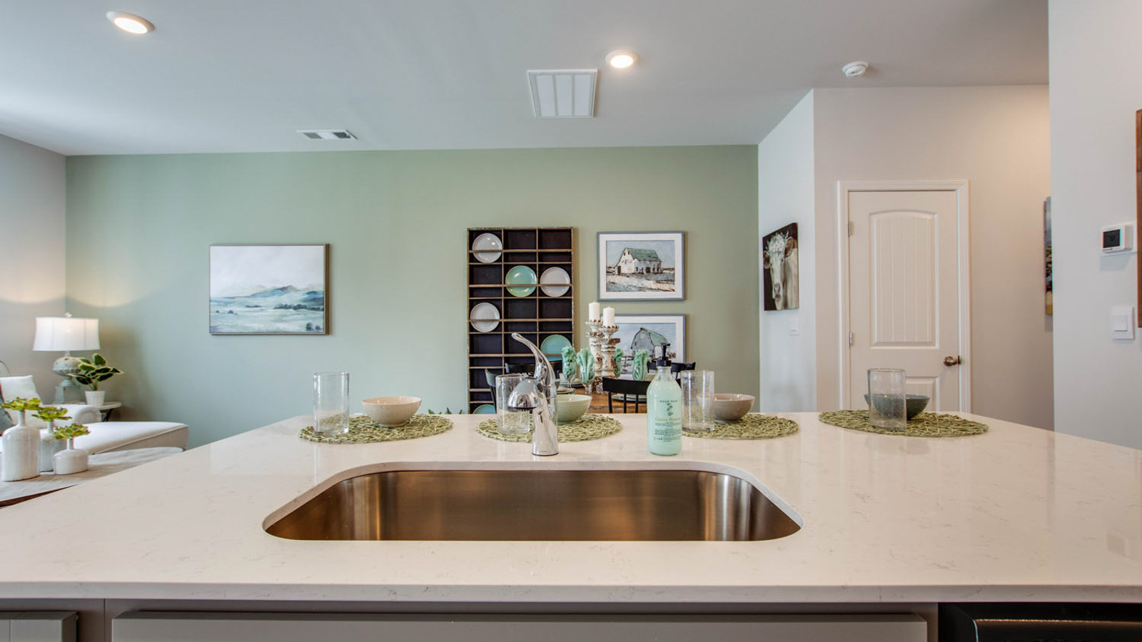 Central kitchen island anchors the home adding a dining option, full sink, pantry and storage, multi-prep zones