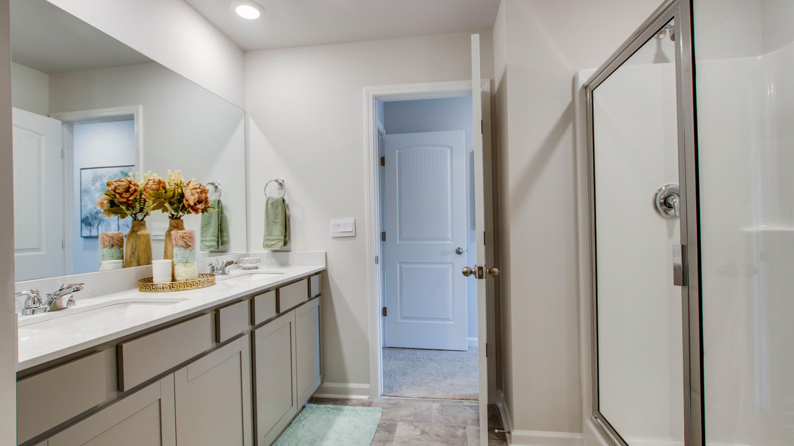 Sleek family-guest bath with single sink, mirror, cabinets, and shower-tub combination at River Landing