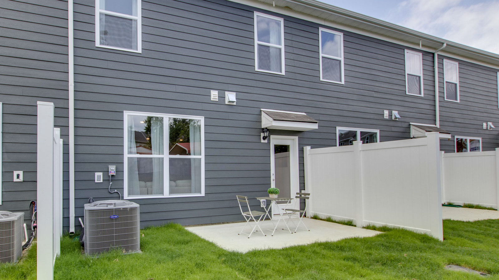 New townhome by D.R. Horton featuring a concrete patio for seating, grill setup, and a transition from indoor to outdoor living