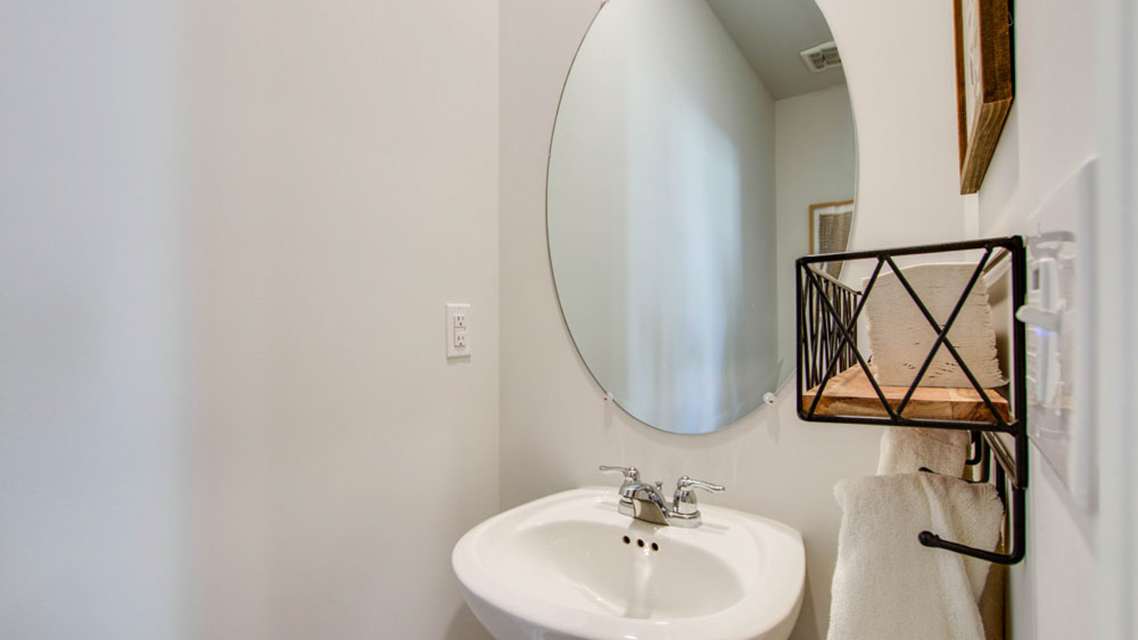 Half bath with door opening to hallway, pedestal sink, mirror visible with shiny faucet, River Landing