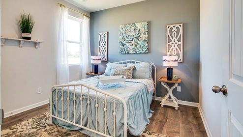 Bedroom with light brown flooring.