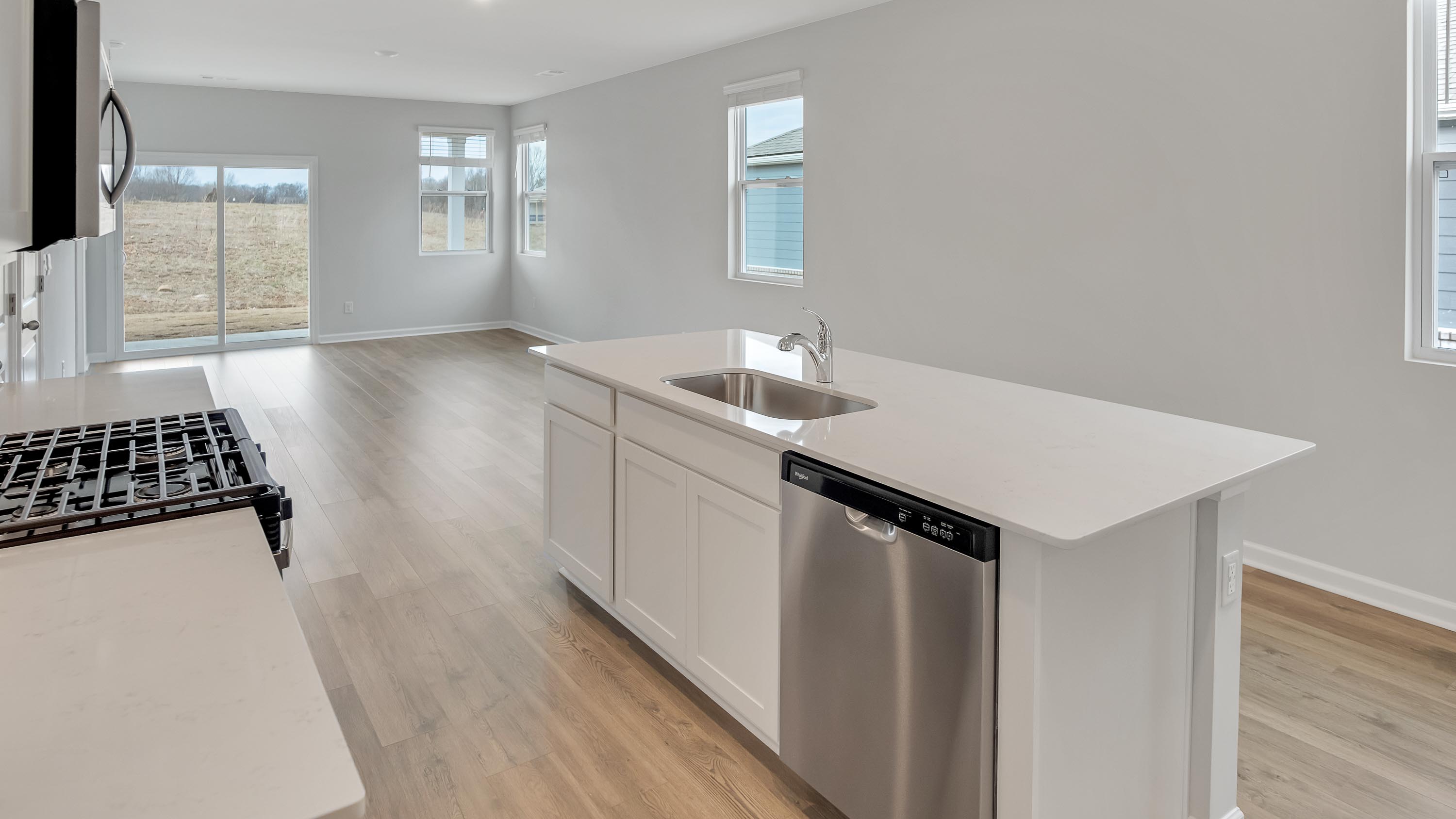 Kitchen island with white cabinets and stainless steel appliances.