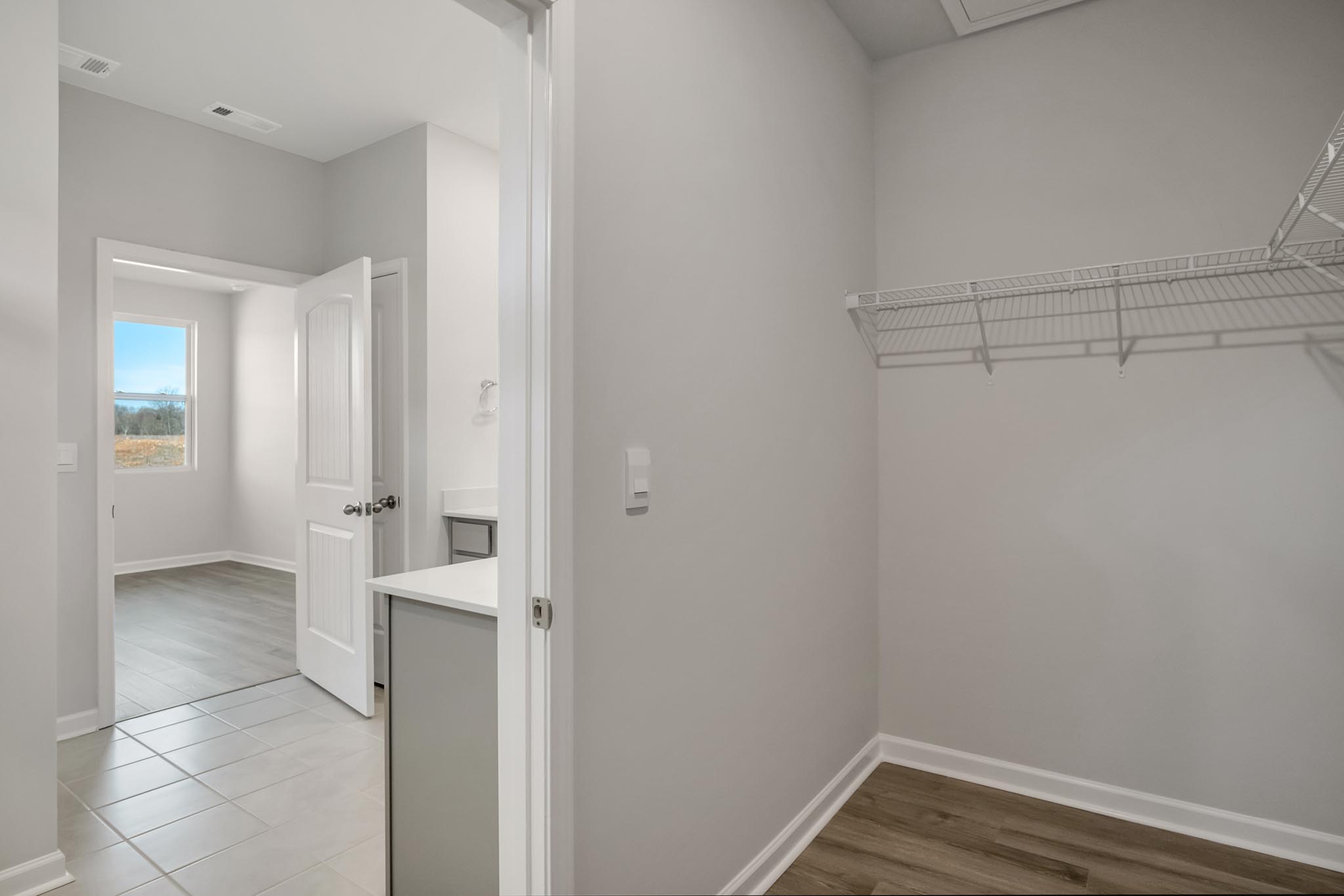 Walk in closet with tile flooring.