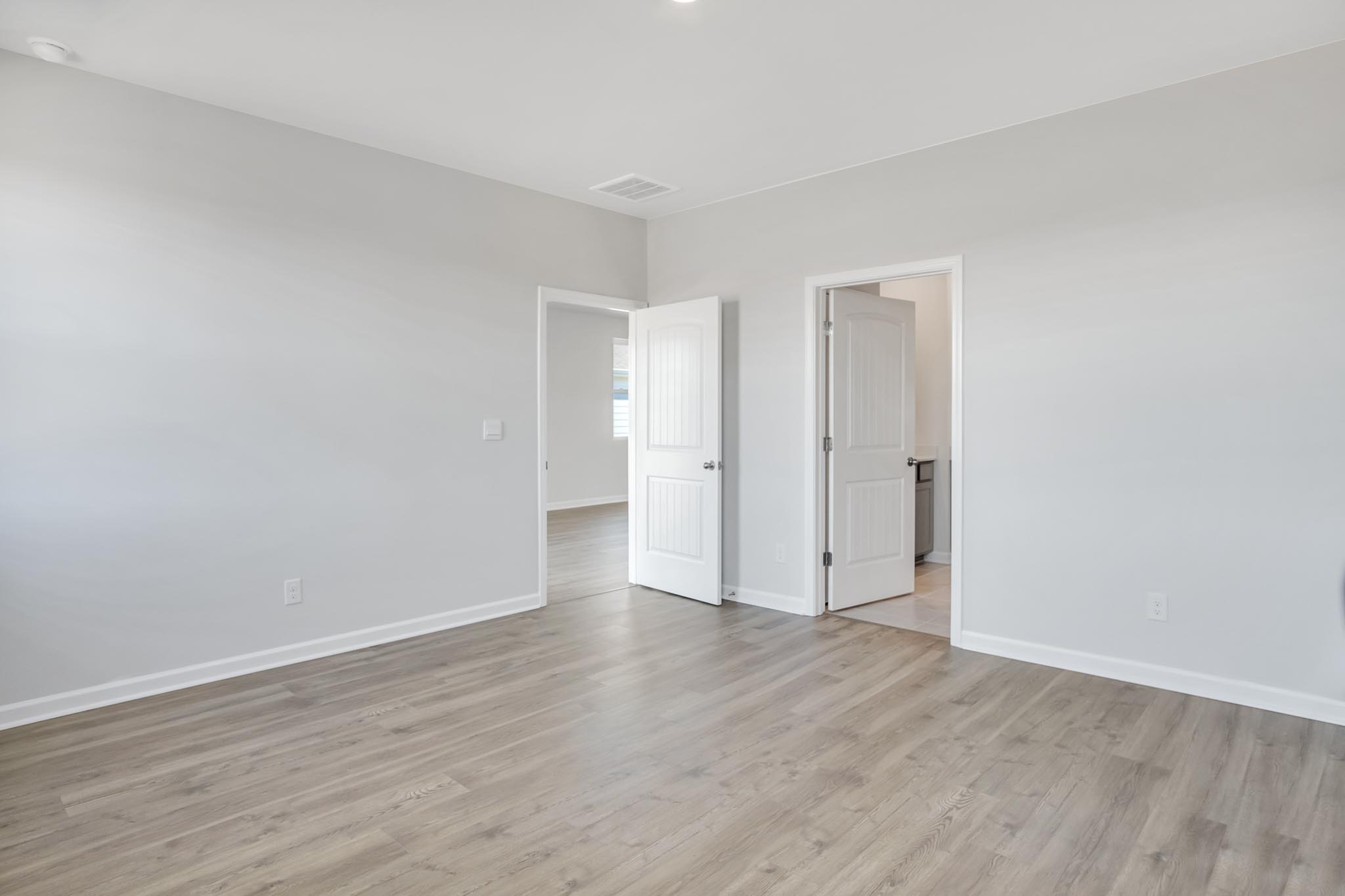 Bedroom with light brown flooring.
