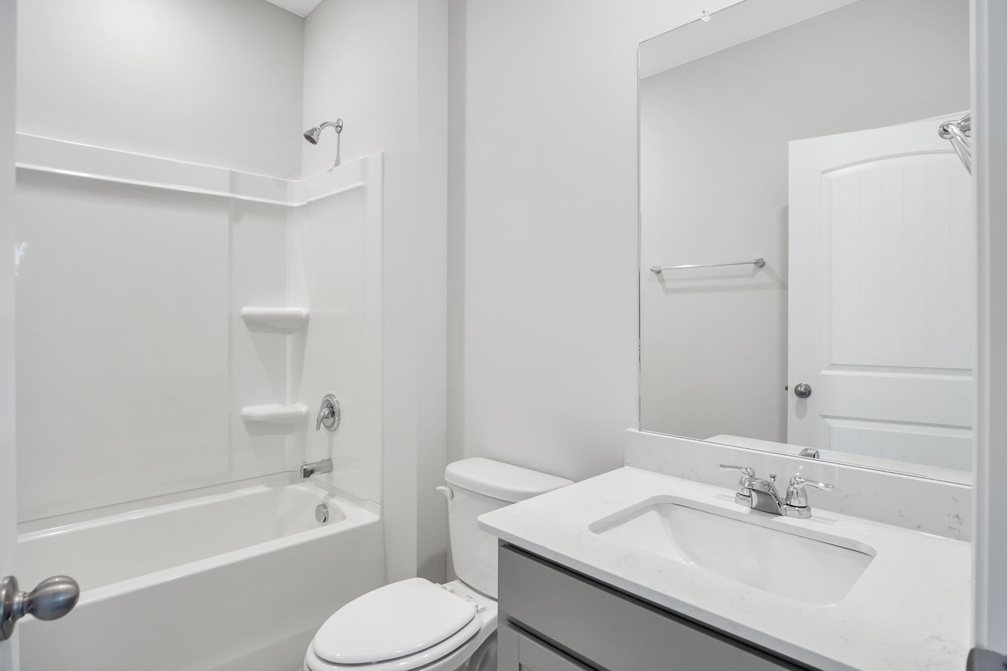 Bathroom with single white sink and shower.