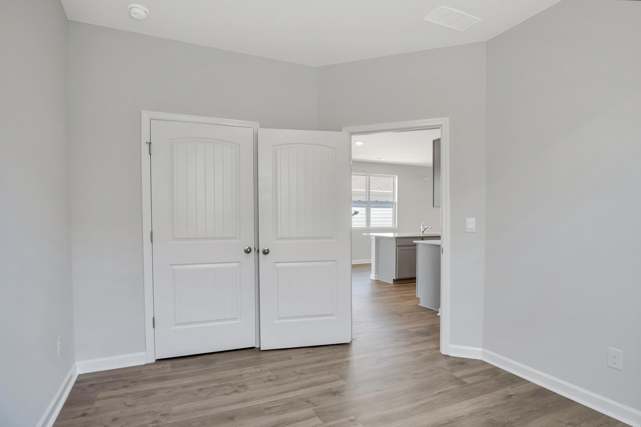 Bedroom with closet and light brown flooring.