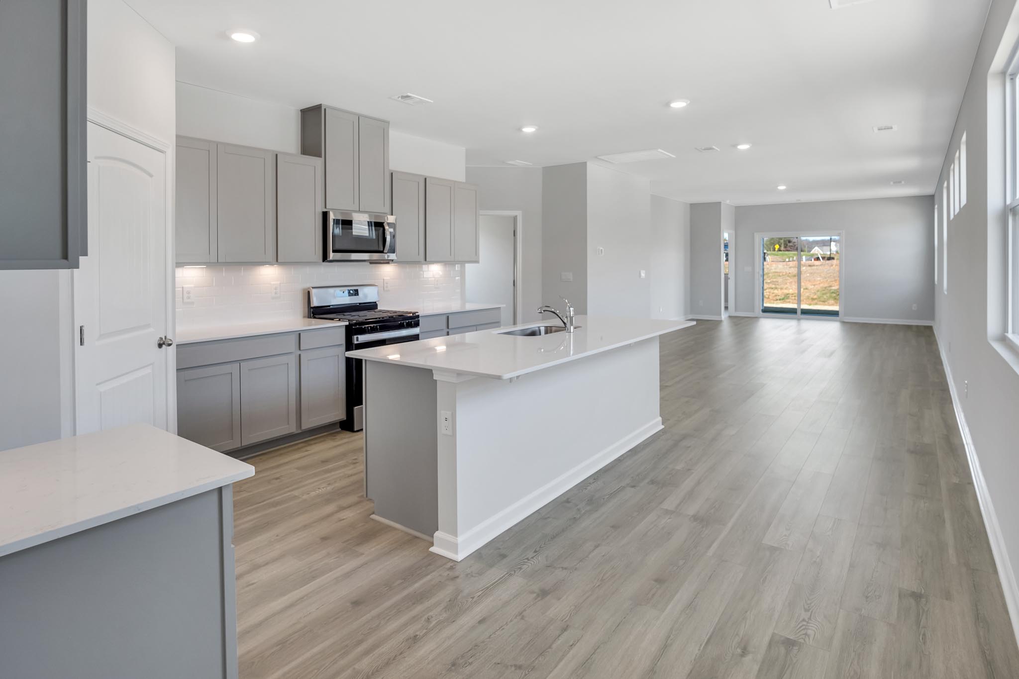 Kitchen with large island and white countertops.