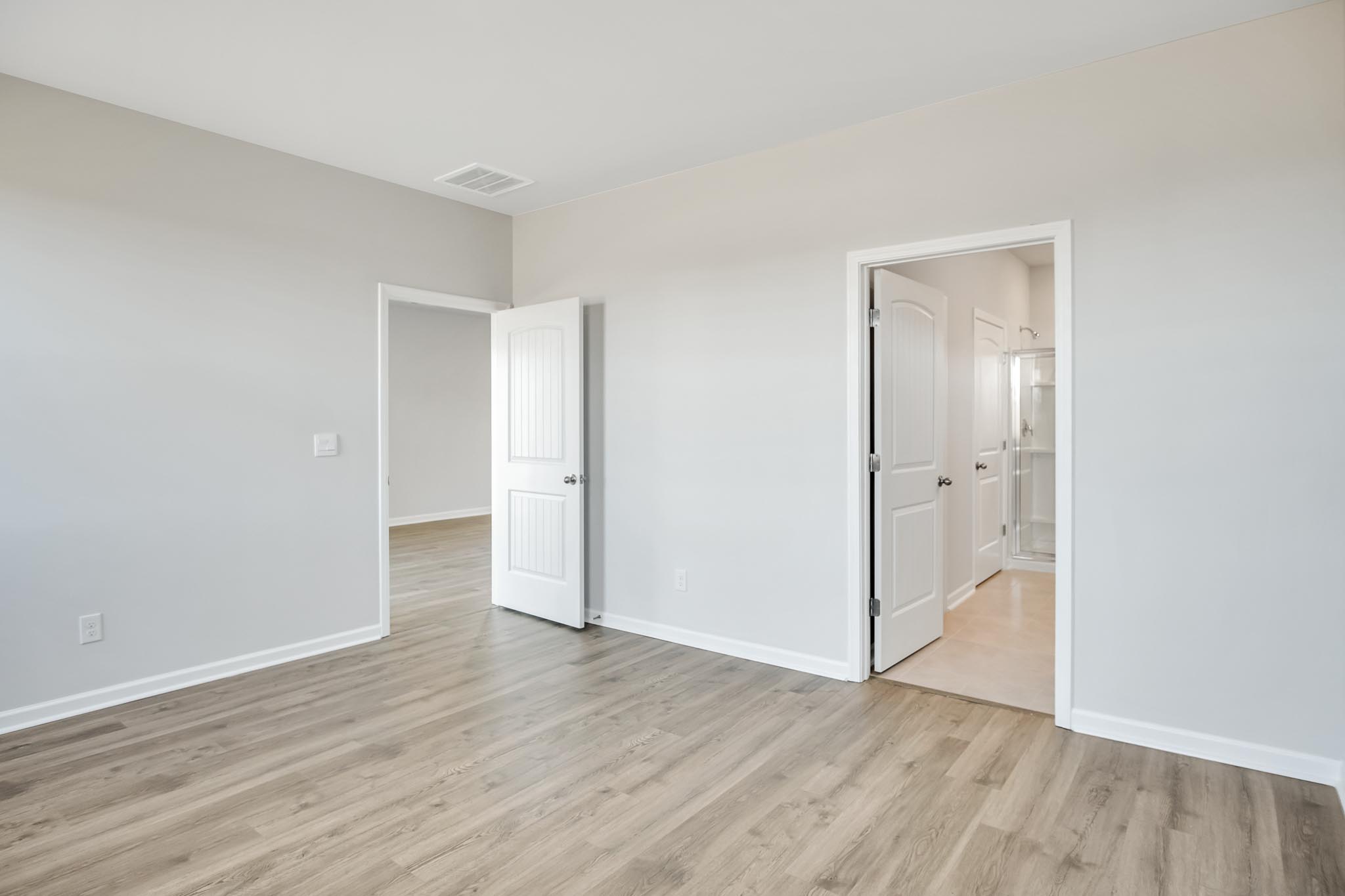 Bedroom with light brown flooring.