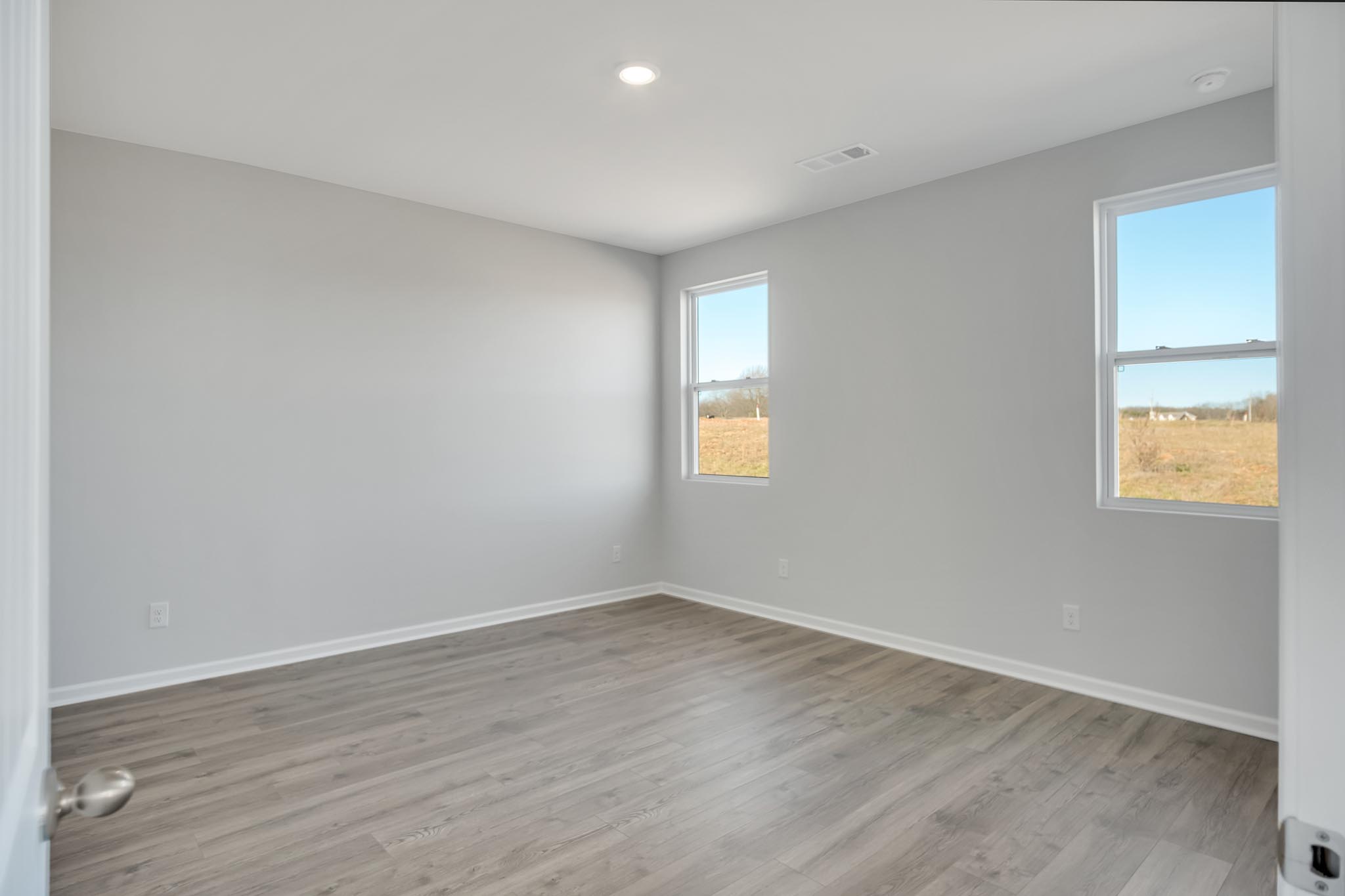 Bedroom with windows for natural lighting.