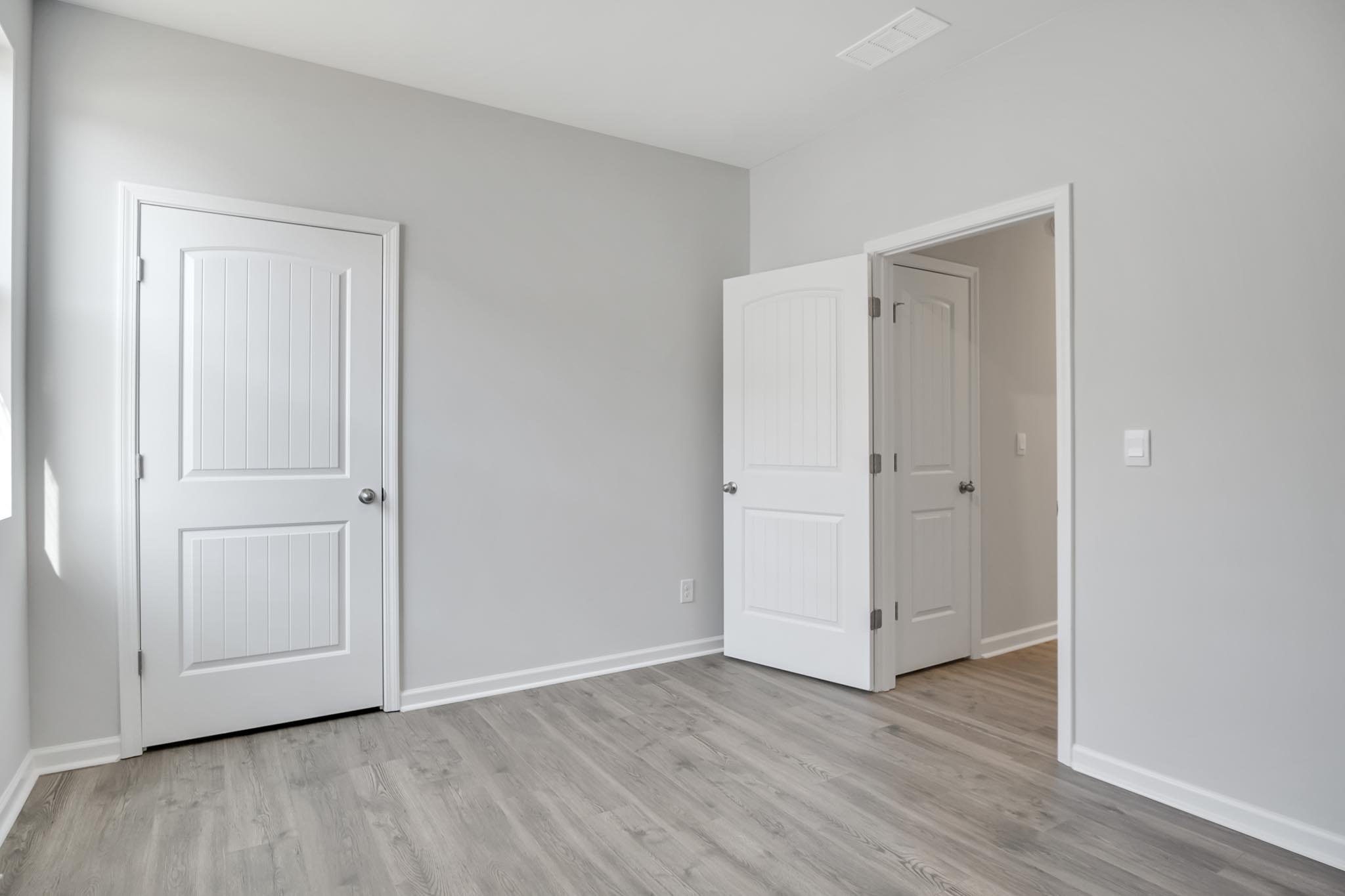 Bedroom with closet and window for natural lighting.