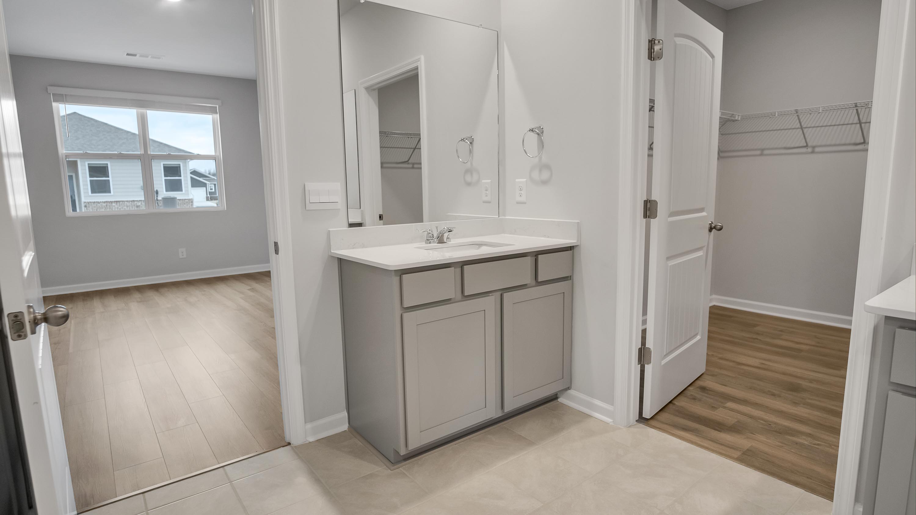 New build home adds a thoughtful private ensuite, walk-in shower, walk-in closet, full vanity, mirror, backyard views