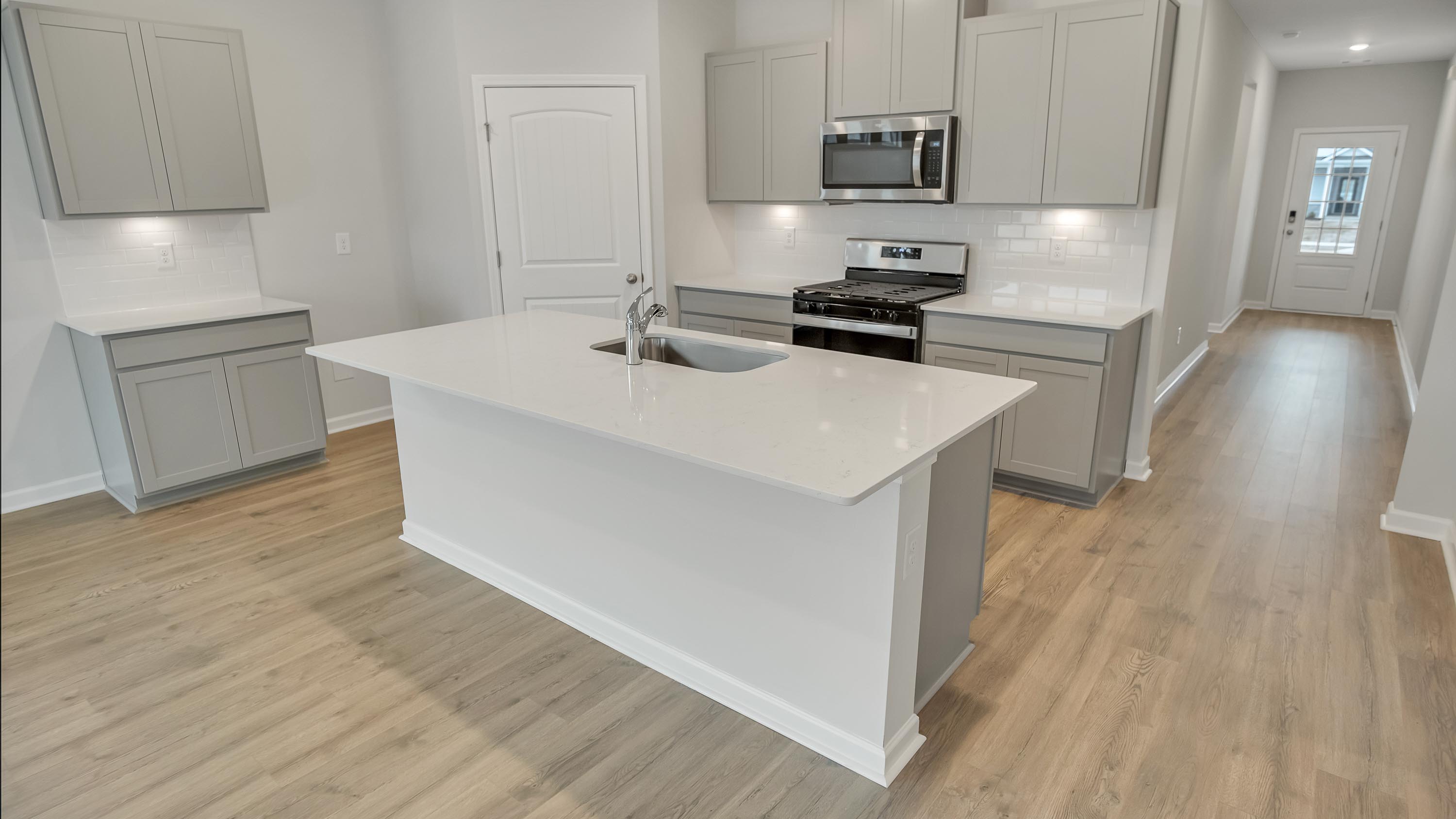 Central kitchen island anchors the home adding a dining option, full sink, pantry and storage, multi-prep zones