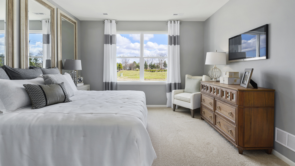 Primary bedroom with large window for natural lighting.