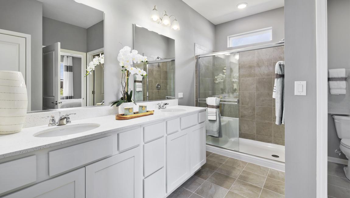 Bathroom with double vanity sinks and walk in shower.