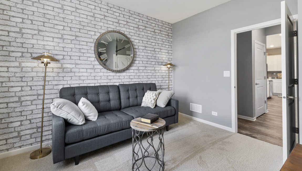Bedroom with carpeted floors and designed accent wall.