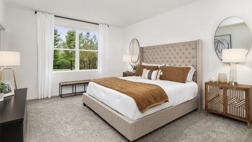 Primary bedroom with carpeted floors and large window for natural lighting.