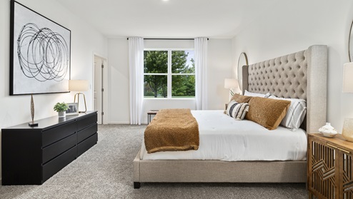 Primary bedroom with large window for natural lighting.