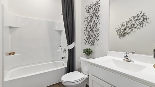 Bathroom with single sink and step in shower with toilet.