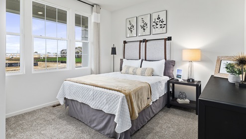 Bedroom with carpeted floors and large window for natural lighting.