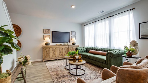 Living room in new, open-concept home with windows and natural lighting
