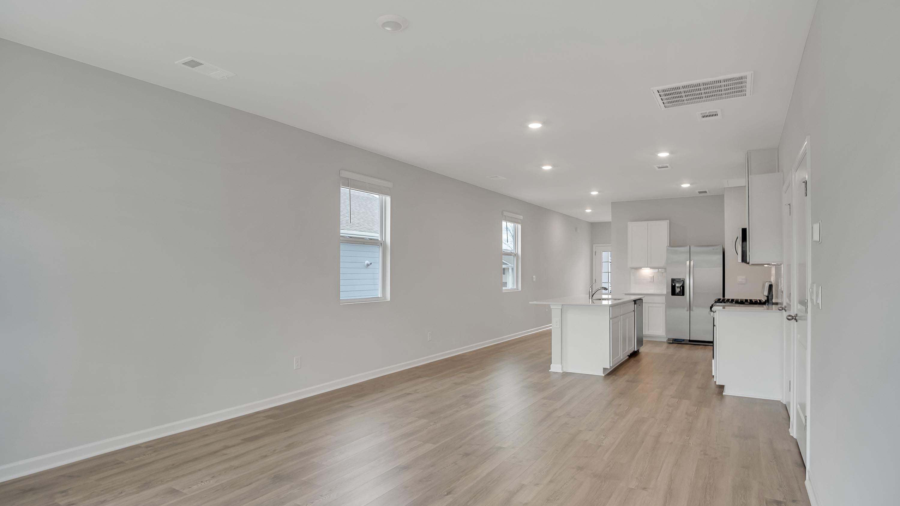Living room in new, open-concept home with windows and natural lighting