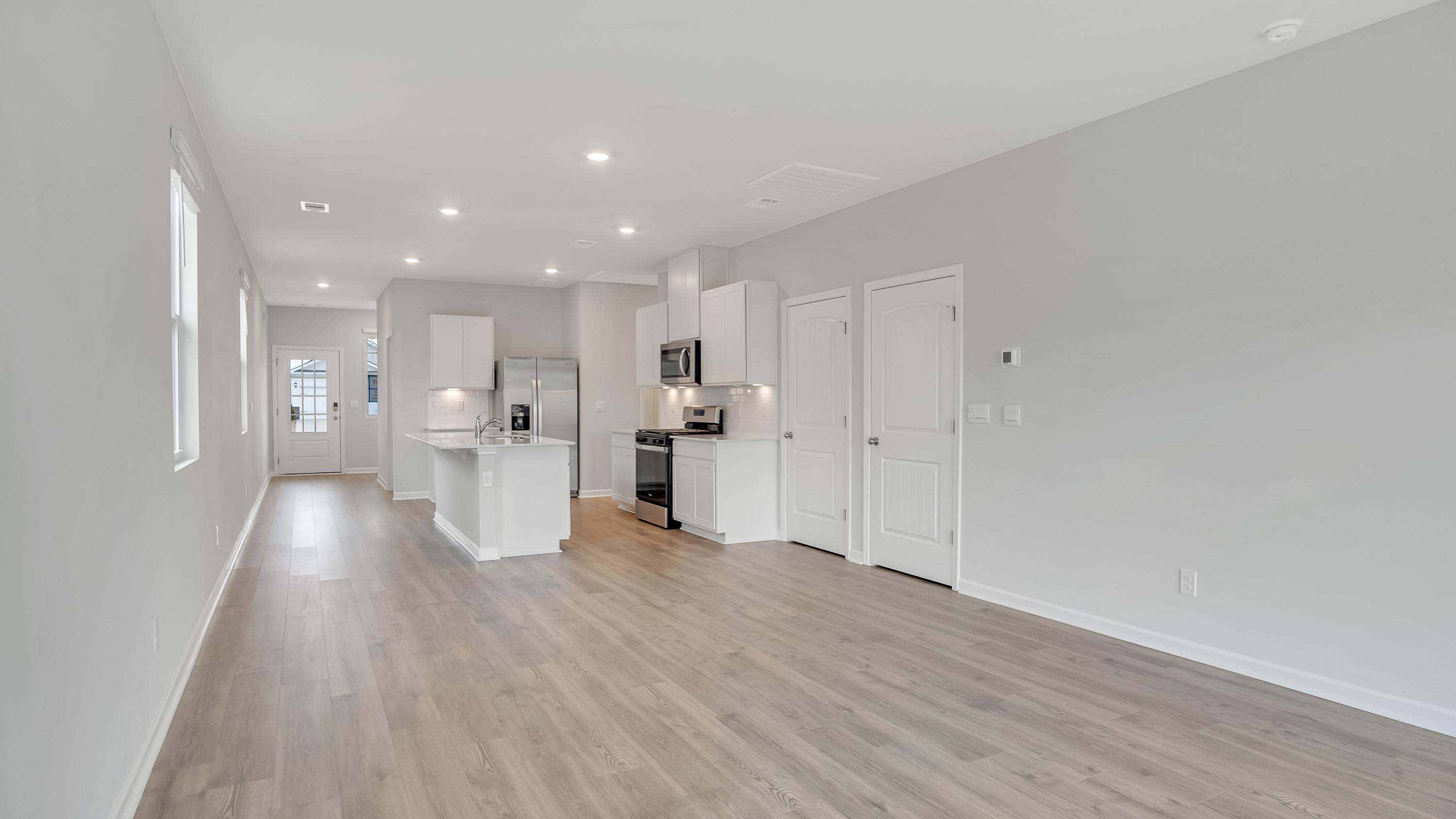 Living room in new, open-concept home with windows and natural lighting