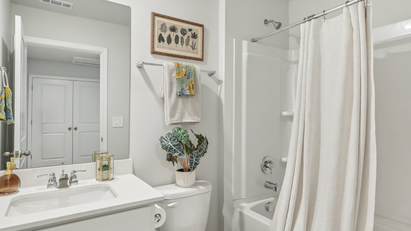 Secondary bathroom adds style, comfort and a combination shower-tub, cabinet storage, vanity, mirror at Saddle Trace Townhomes