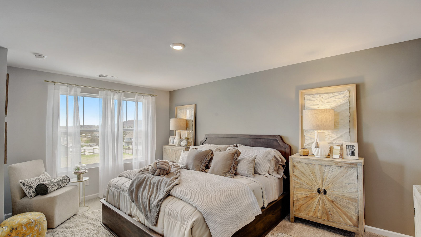 Primary bedroom features ample space, double windows, soft carpet, a stylish walk-in closet, and a private ensuite bath