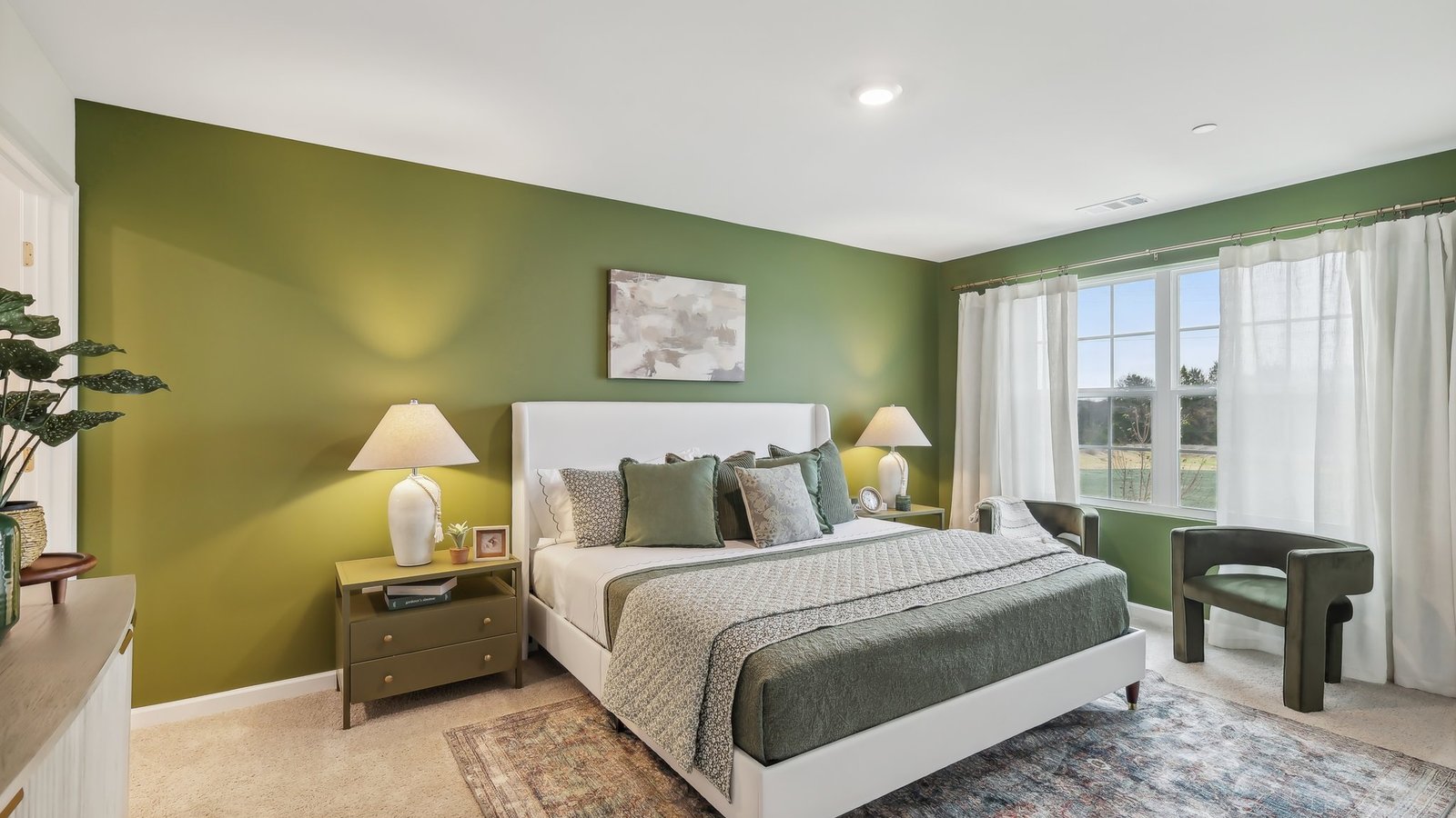 Primary bedroom with carpeted floors and large window for natural lighting.