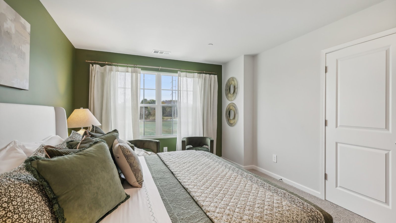 Primary bedroom with large window for natural lighting.