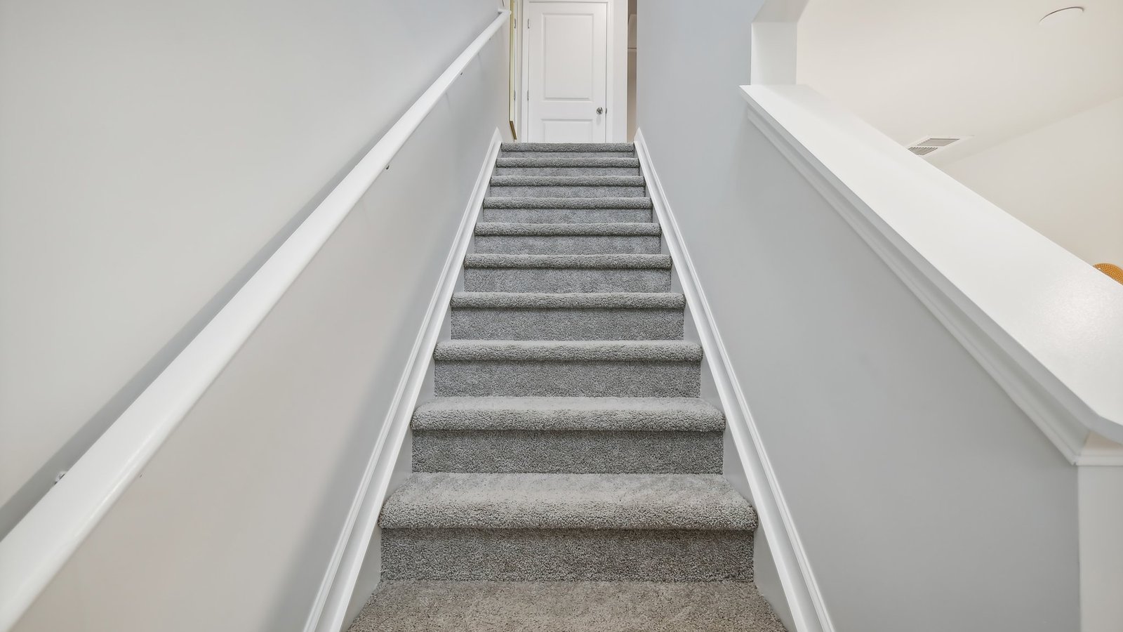 Carpeted stairs with side railing.