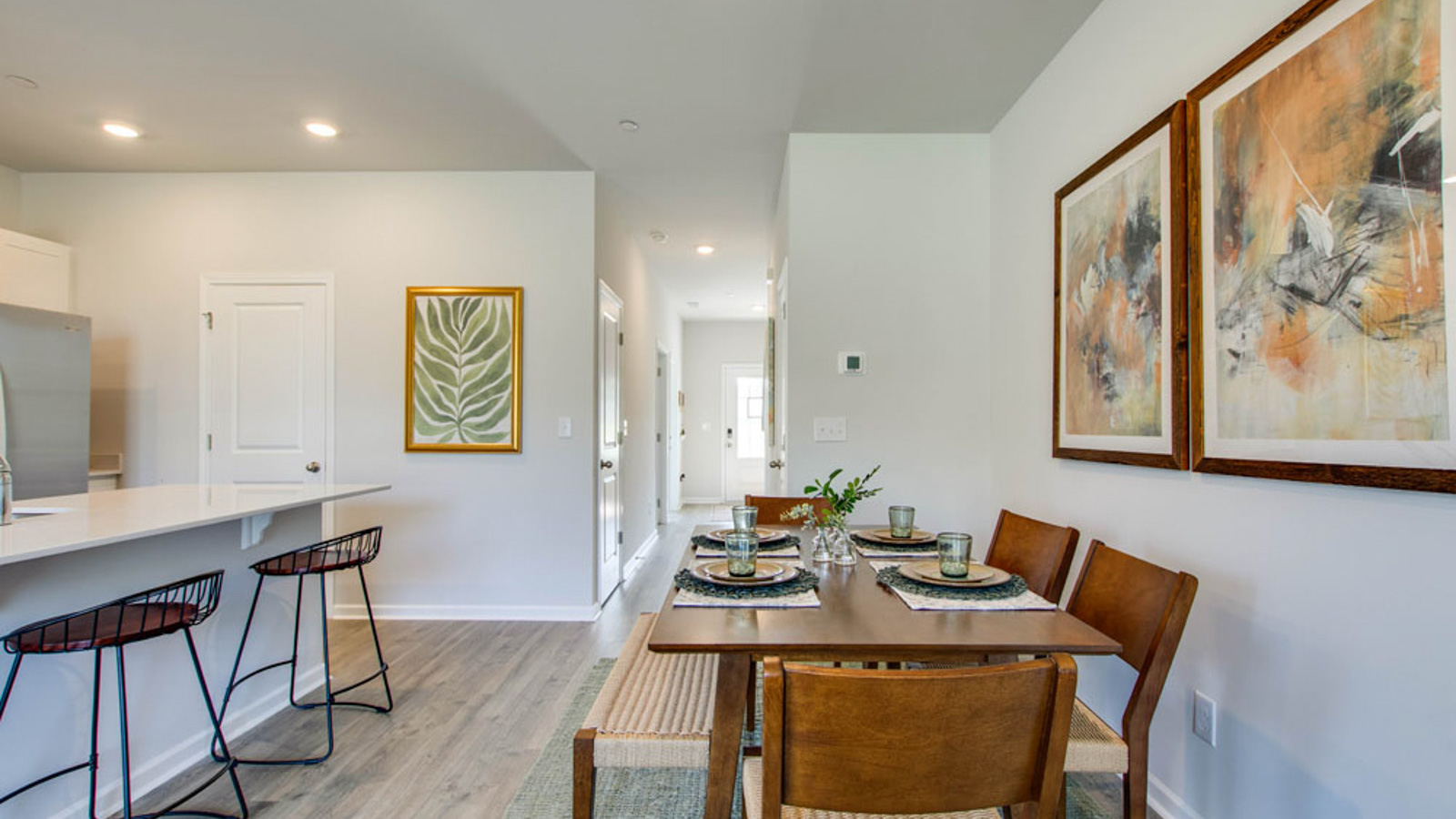 Dining room looking toward modern kitchen with sink and new appliance suite included, next to backyard at King's Landing