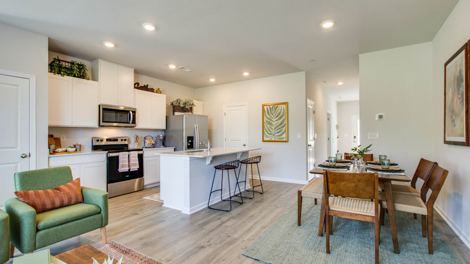 Living room looking to kitchen, dining, outdoor areas in this new townhome features natural light, with fresh concept flow