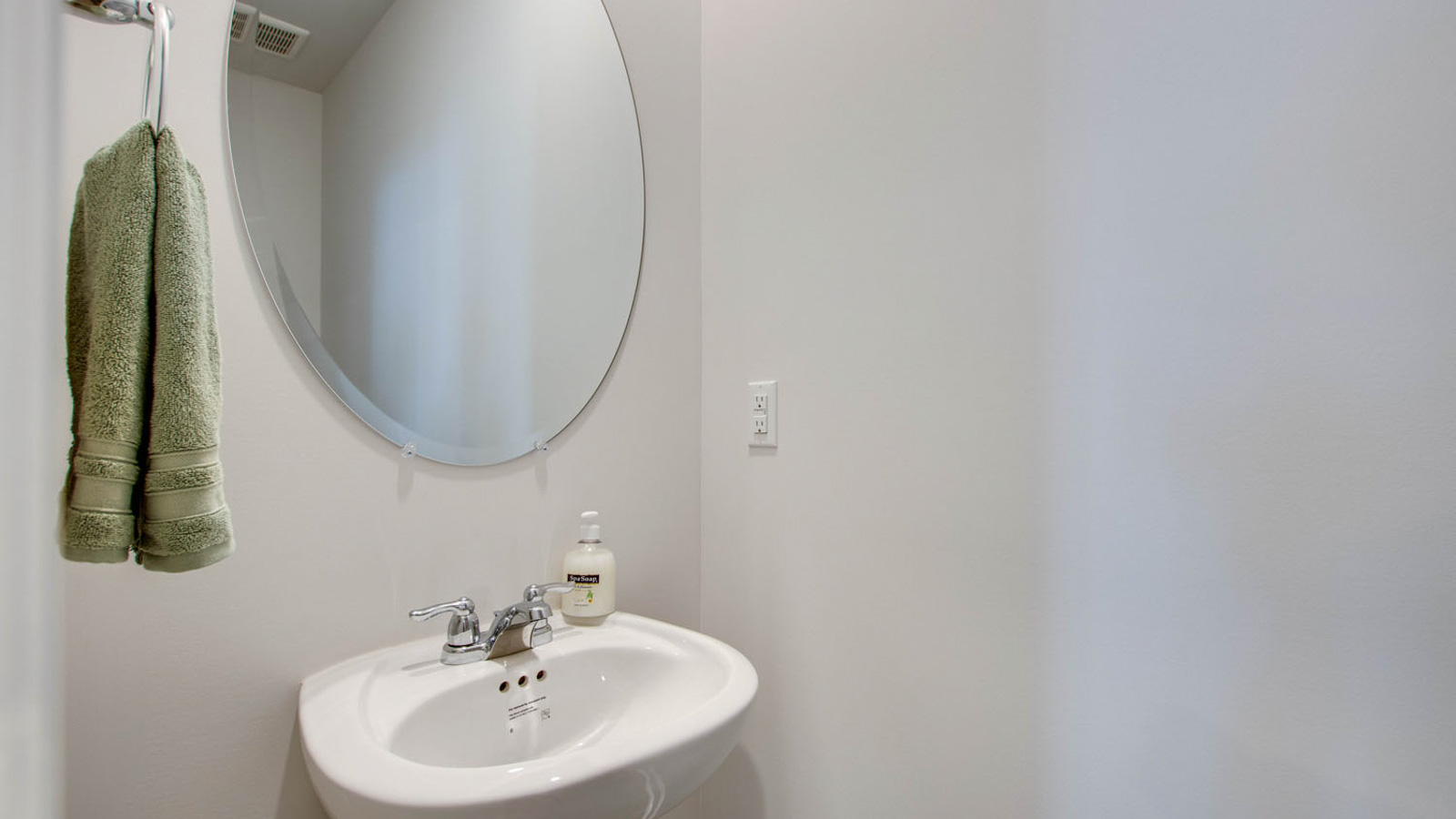 Half bath with door opening to hallway, pedestal sink, mirror visible with shiny faucet in King's Landing