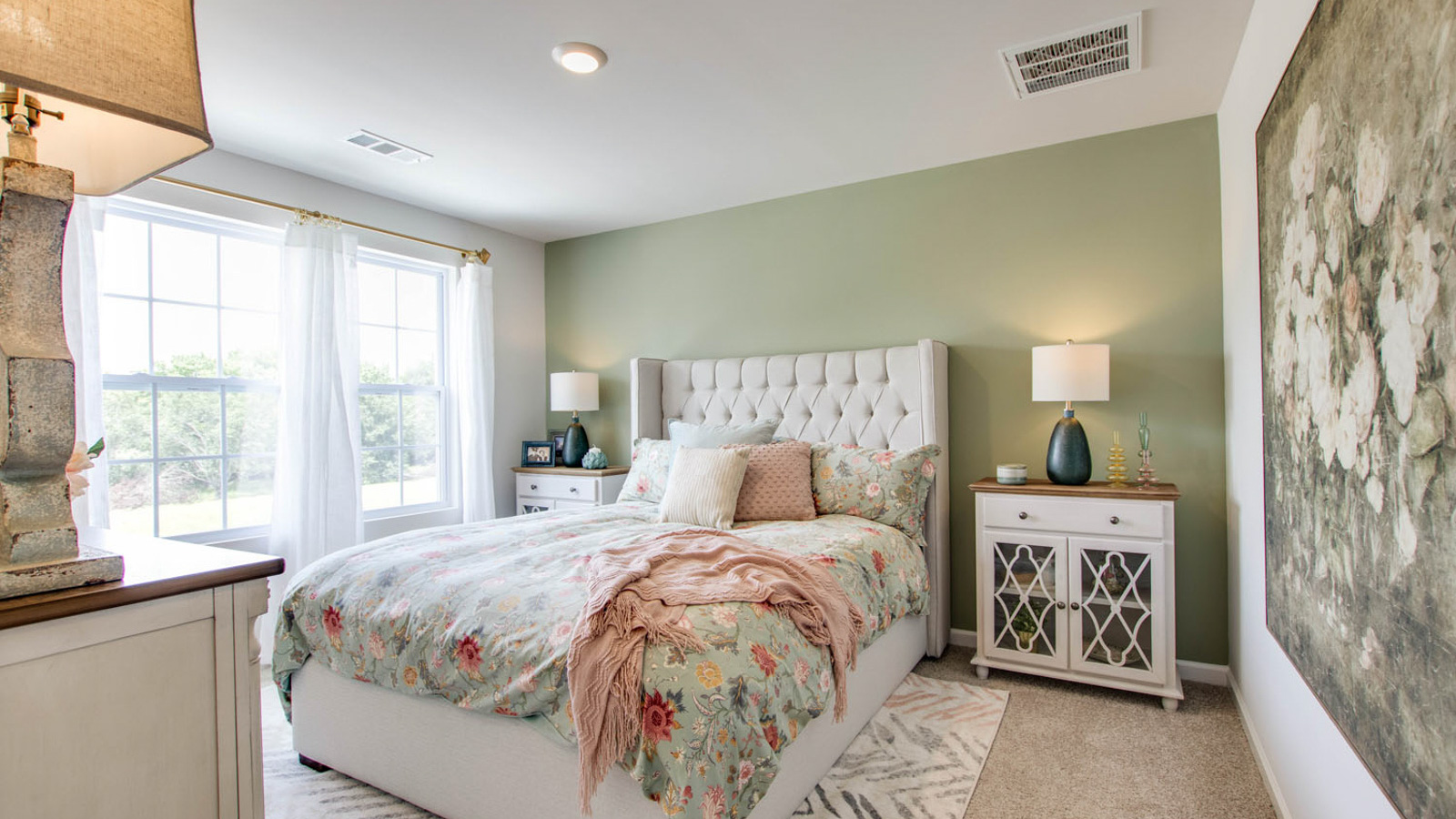 Primary bedroom in this townhome features double windows, soft carpet, walk-in closet, and a private spa-inspired ensuite bath