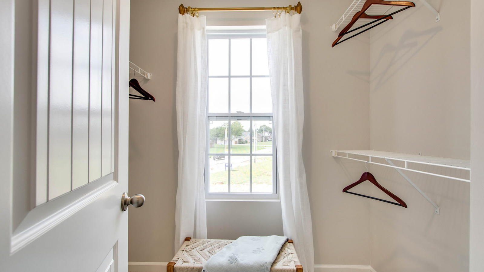 Primary suite walk-in closet in King's Landing new home with built-in shelving and generous storage