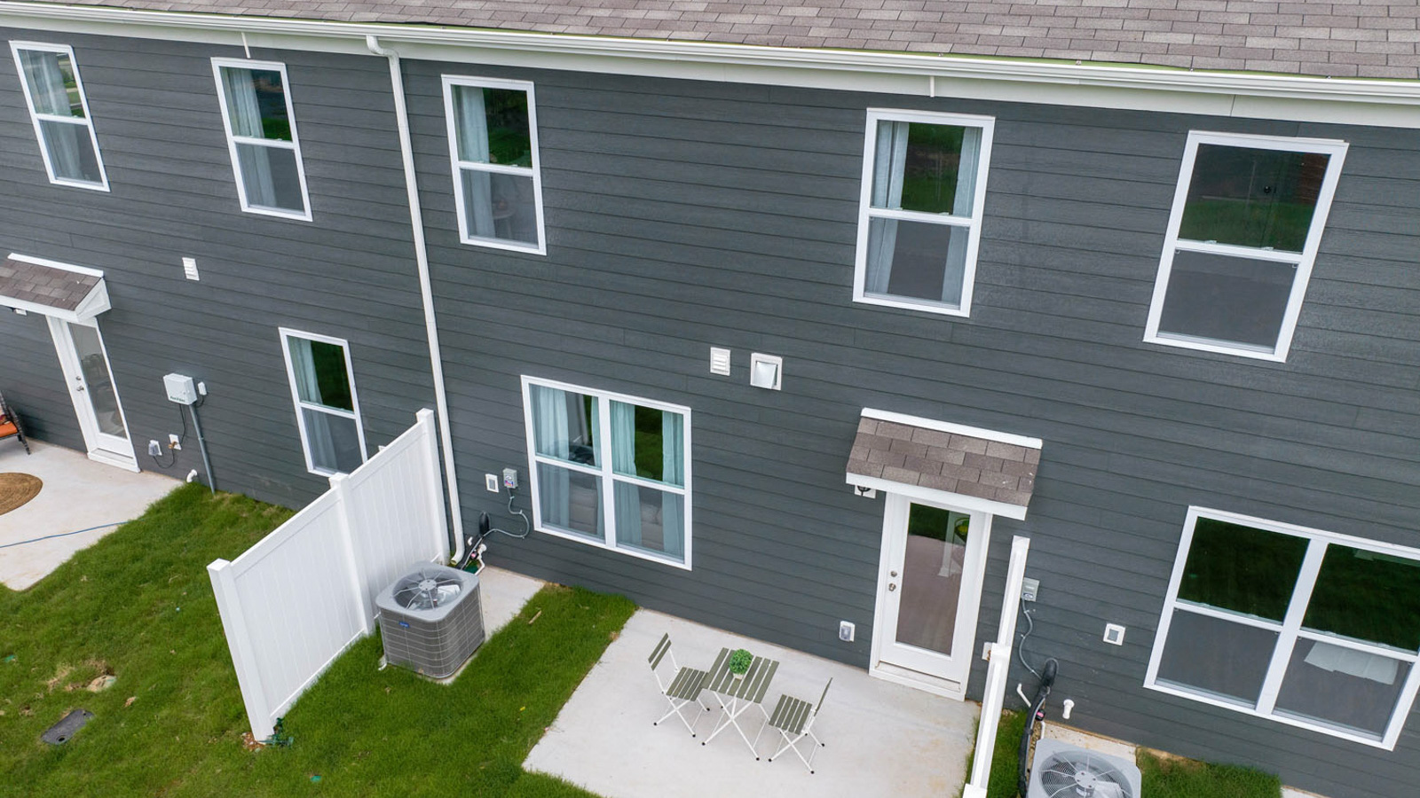 Backyard with concrete patio area offering room for seating, grill setup, and a transition from indoor to outdoor living