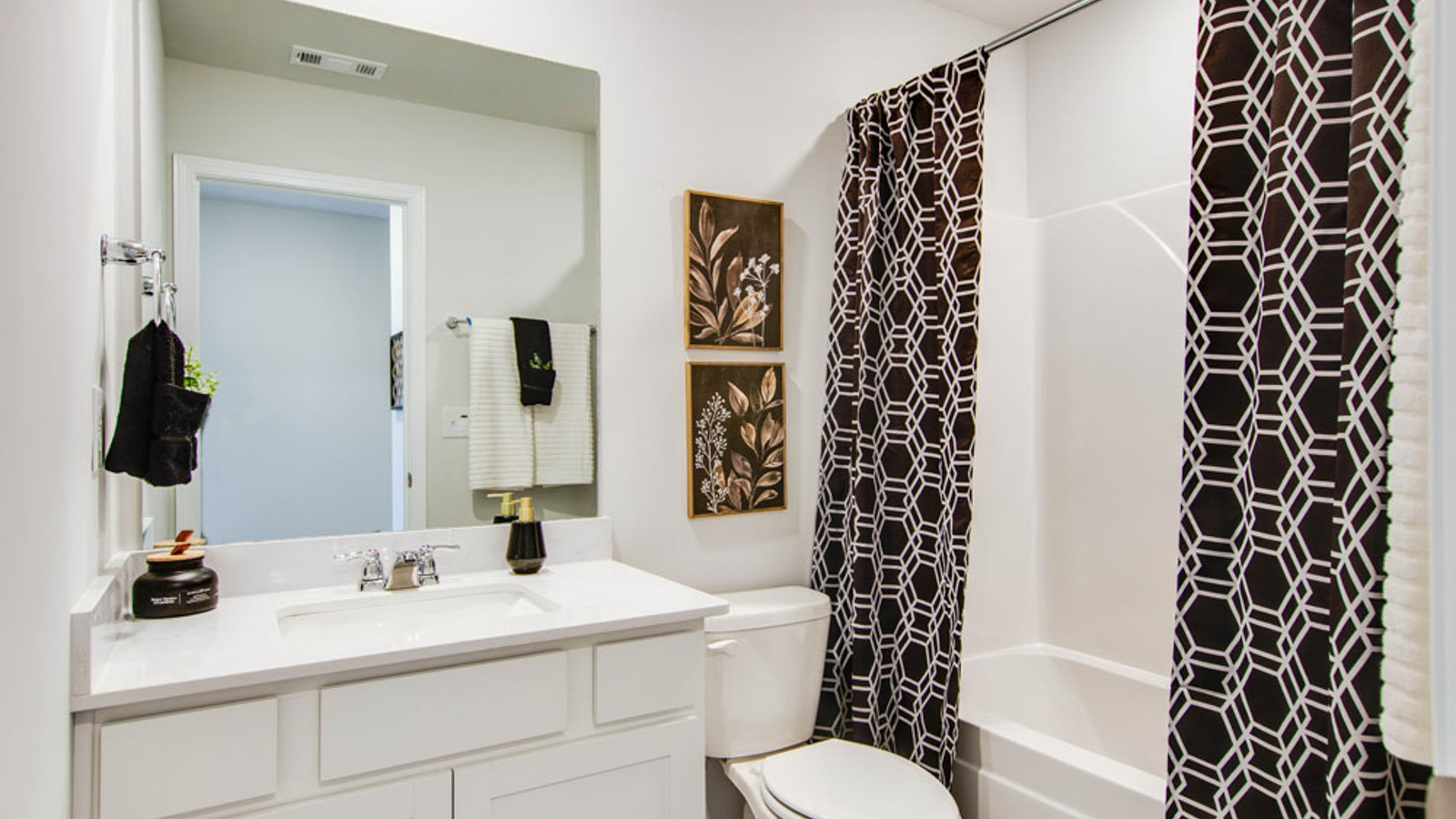 Family bathroom with stylish vanity, mirror, polished fixtures, cabinets, tub-shower combo in King's Landing