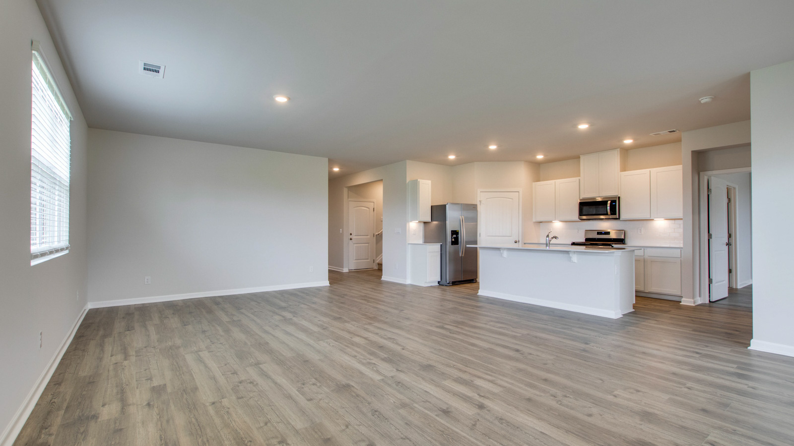 Living room in new, open-concept home with windows and natural lighting