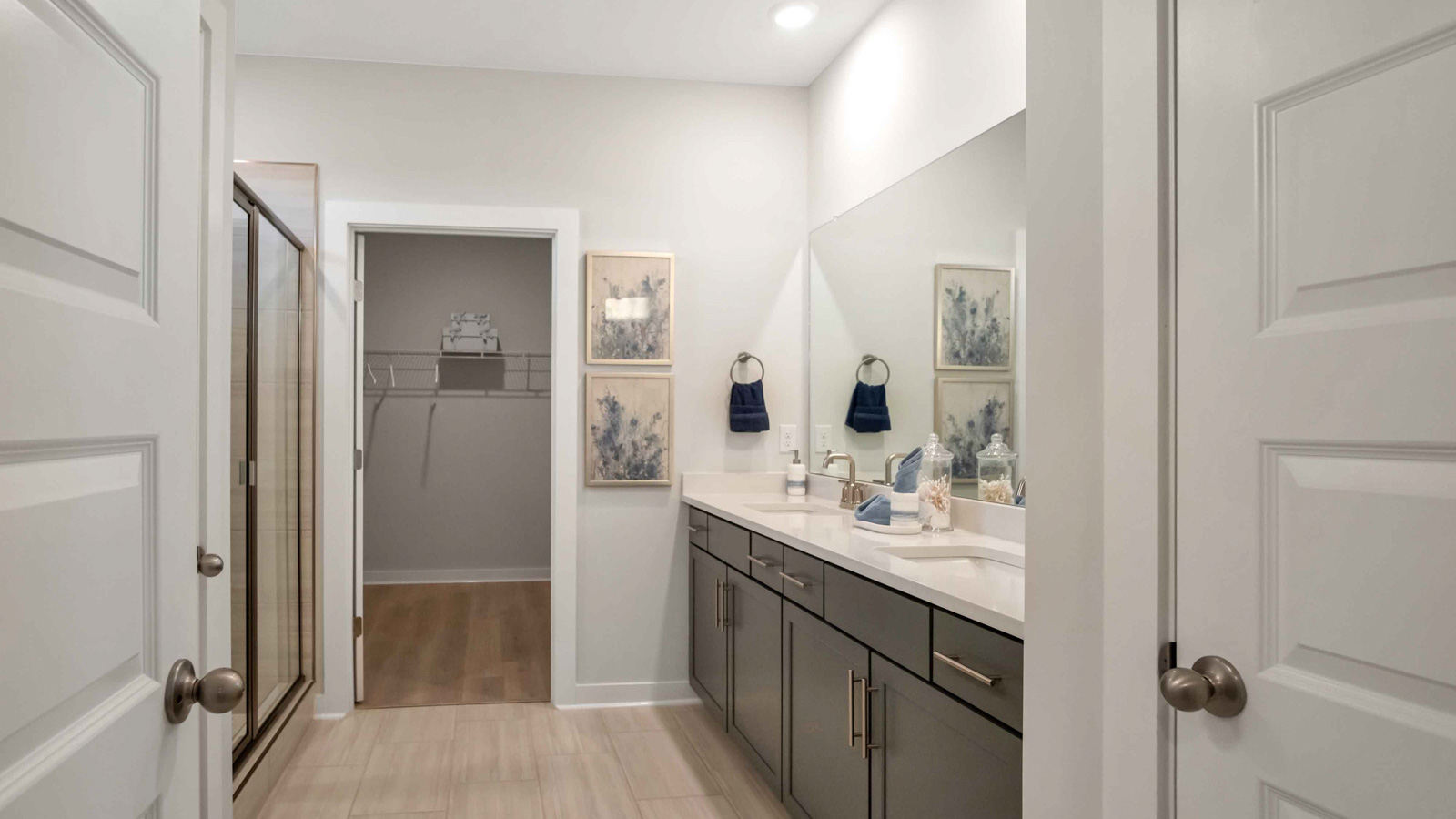 Family bathroom with stylish vanity, mirror, polished fixtures, cabinets, tub-shower combo in Nexus South