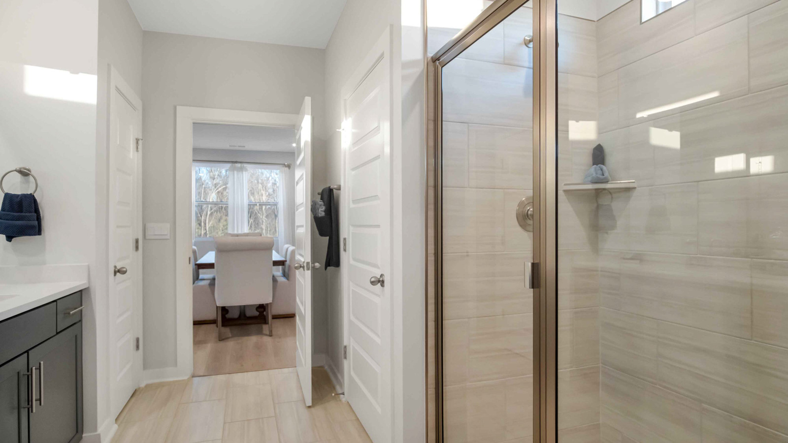 Secondary bathroom adds style and comfort with a combination shower-tub, cabinet storage, vanity, mirror at Nexus South