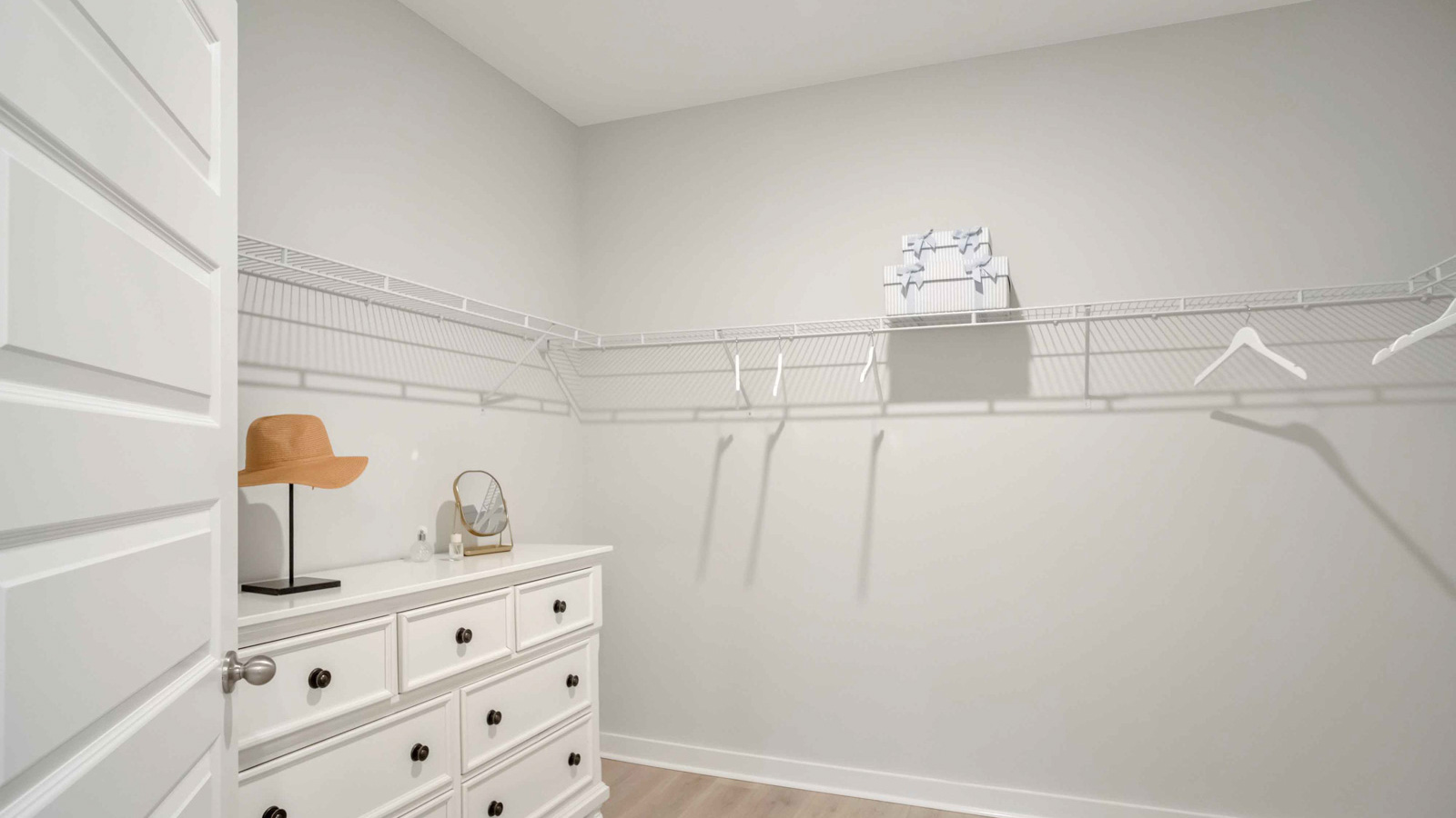 Interior view of walk-in closet in the primary bedroom and spa-inspired ensuite in Nexus South  home by D.R. Horton